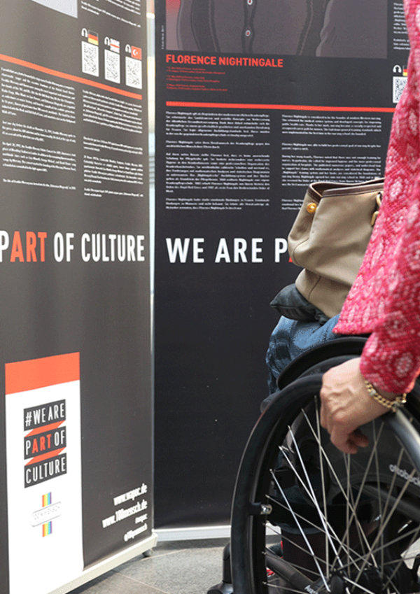 Rollstuhlfahrerin betrachtet einen WAPOC Banner